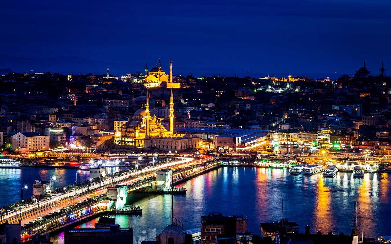 Galata Bridge and the Golden Horn at night with the New Mosque illuminated behind