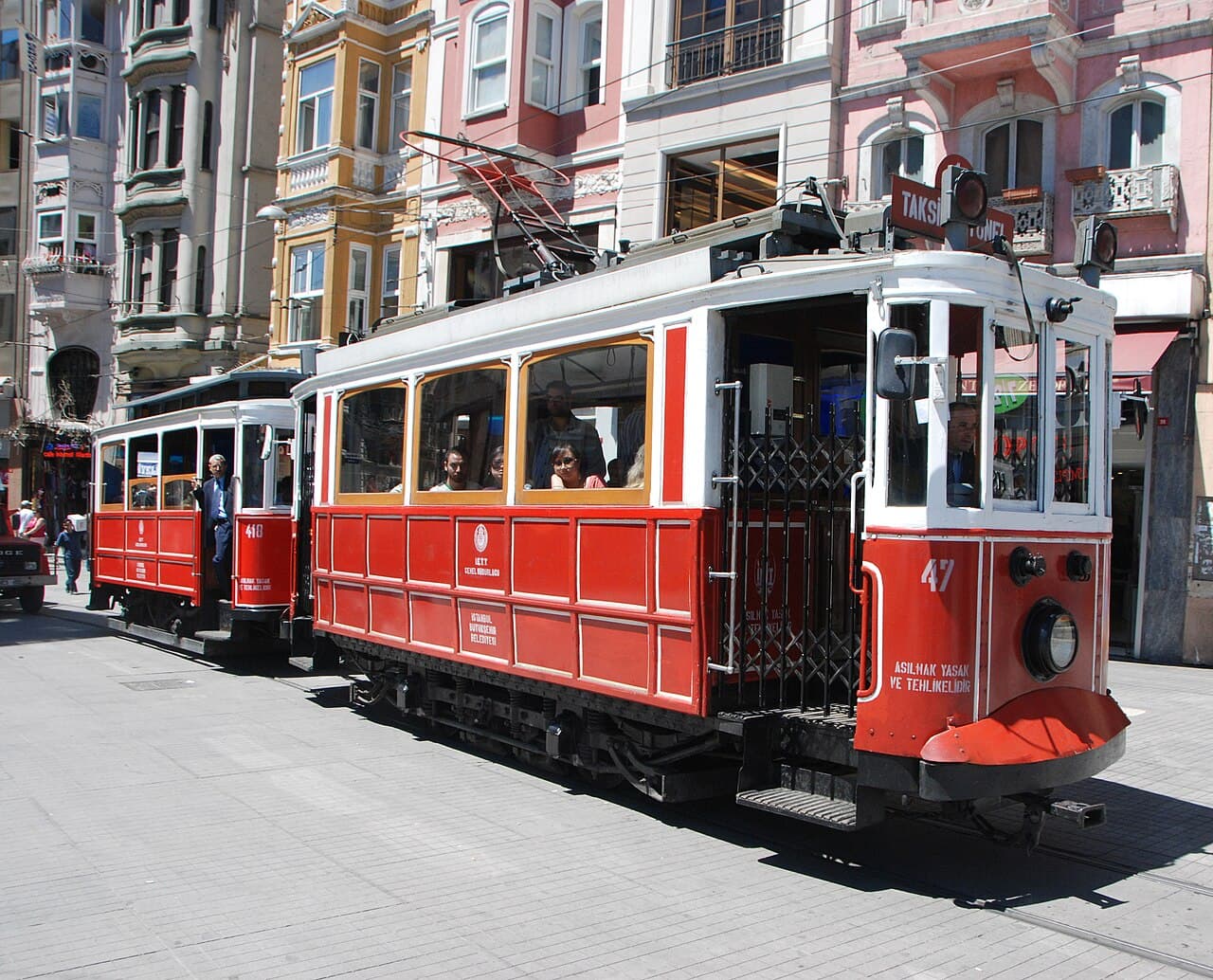 Red nostalgic tram picking up passengers on Istiklal Street in Istanbul